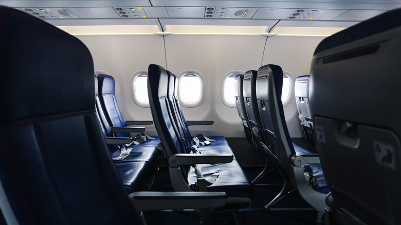 Rows of empty plane seats inside an economy cabin