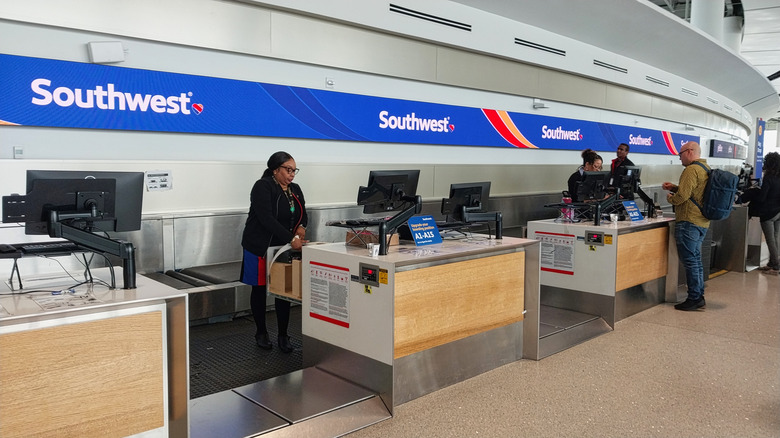 Employees and customers at a Southwest Airlines counter inside an airport