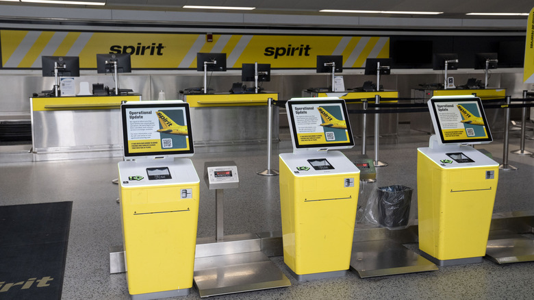 A dark check-in area and Spirit airlines kiosks at Detroit-Metro Airport