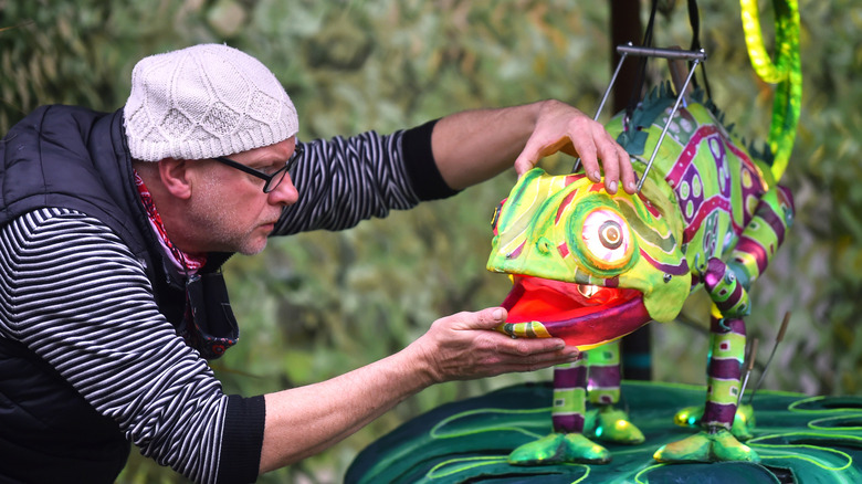 A worker is seen preparing a puppet chameleon for "Lanterns and Light" at Chester Zoo