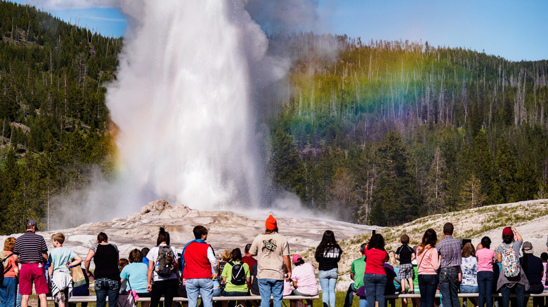 Tourists watching Old Faithful erupt in Yellowstone National Park