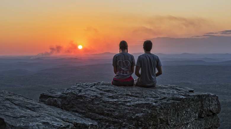 Young couple enjoying sunset at Cheaha Overlook in Cheaha State Park, Alabama