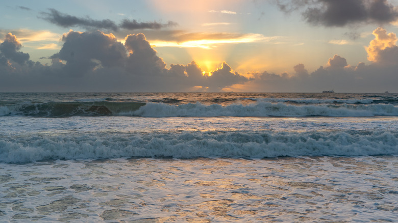 Vibrant sunrise behind the clouds at Cocoa Beach