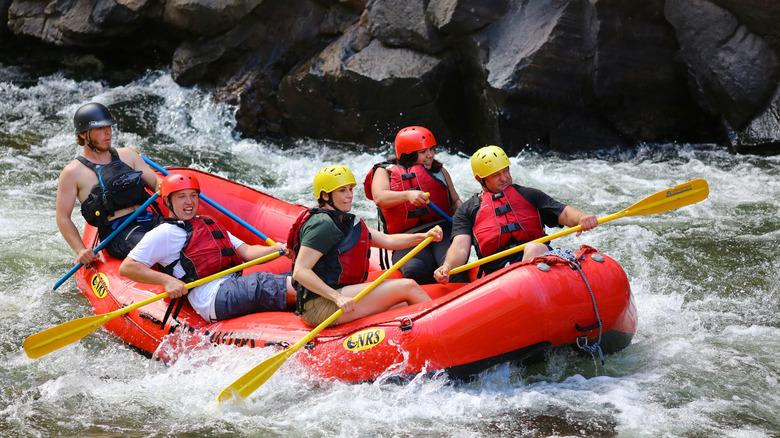 A group of rafters tackle rapids on a river