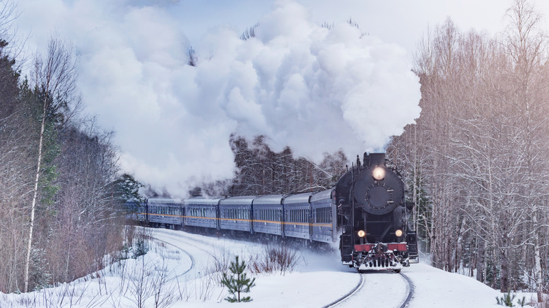 Retro Christmas steam train moves through the snowy forest