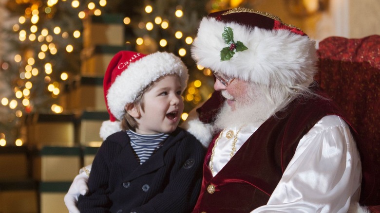 A boy sitting on Santa Claus' lap