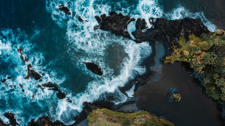 Drone perspective of seascape of the black sand beach in Maui.