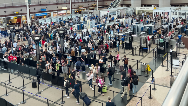 A high-angle view of a crowded TSA security checkpoint at Denver International Airport (DEN)