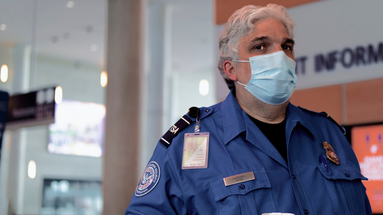 A TSA Agent at Bradley International Airport watches over travelers as they come and go
