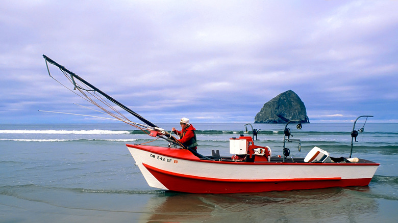 A fisherman in a red and white dory boat in Pacific City, Oregon