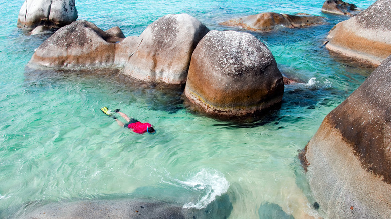 A tourist snorkeling among granite boulders in Virgin Gorda