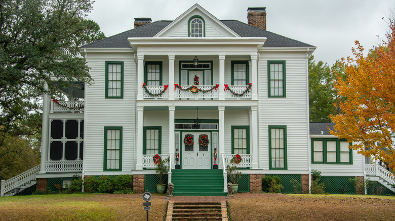 The exterior of the historic Schluter House in Jefferson, Texas, flanked by trees
