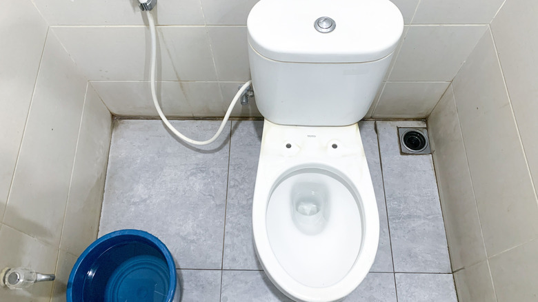 A toilet without a seat inside a tiled bathroom