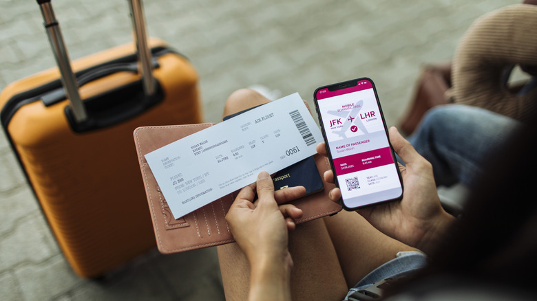 Close-up of the passport, phone, and ticket, with a bag in the distance.
