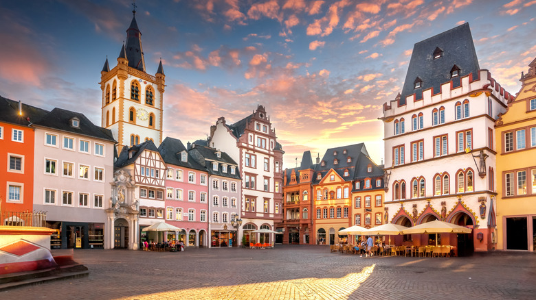 The colorful main square of Trier, Germany, lined with ornate buildings, at sunset
