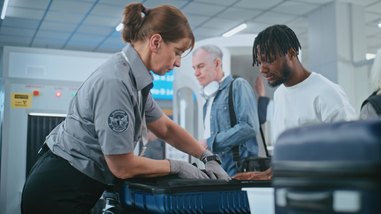A man having his belongings checked by airport security