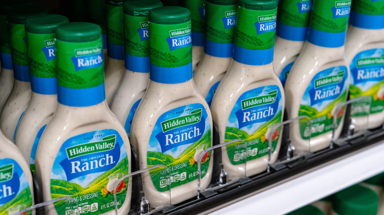 Bottles of Hidden Valley ranch dressing lined up and displayed on a store shelf