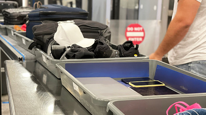 Luggage on a conveyor belt going through an airport security line