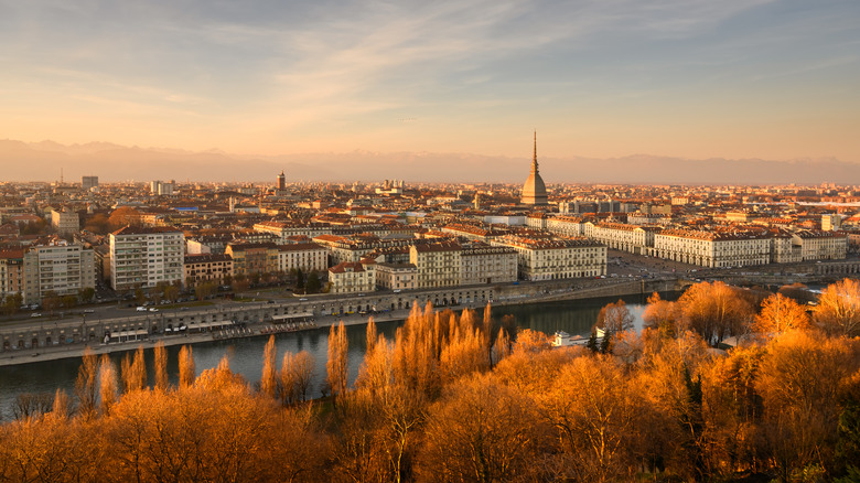 Panoramic view on the autumn city of Turin (Torino) during sunset. Mole Antonellia is visibile, with the Po River in foreground.