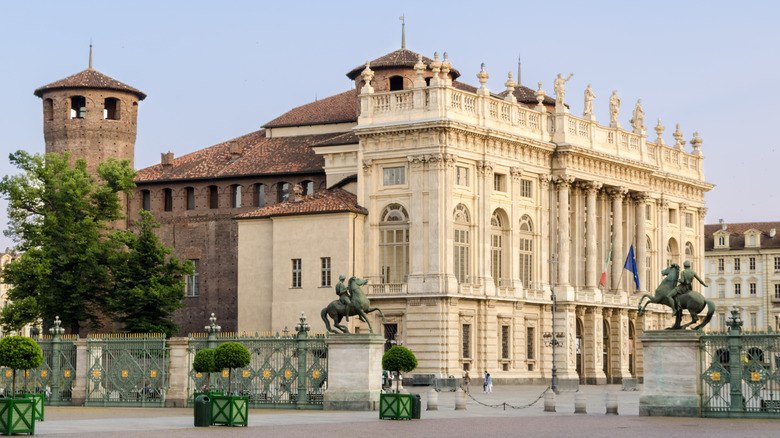 Exterior view of Palazzo Madama in Turin, Italy with horse sculptures and a courtyard in foreground