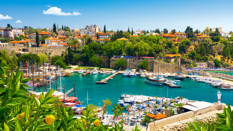 View of the Old Harbor with boats and white buildings in the background in Old Town, Antalya, Turkey on a sunny day