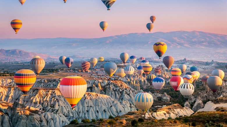 Dozens of hot air balloons floating above Cappdocia, Turkey, at dawn