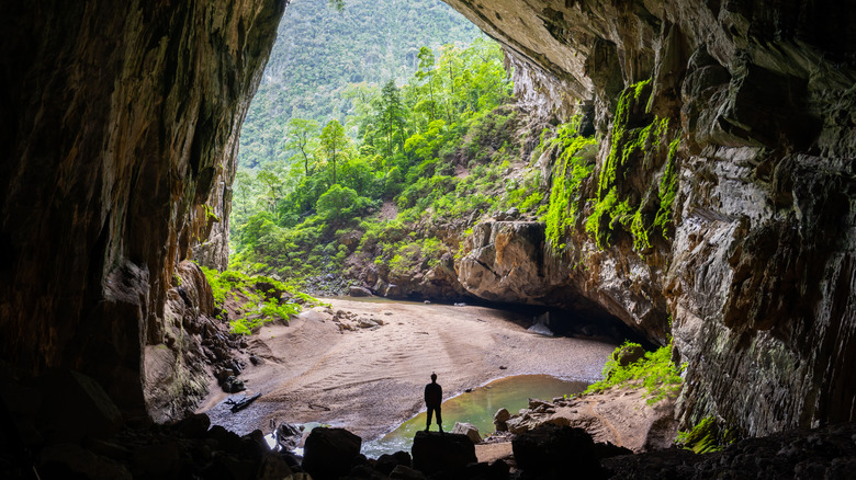 A figure stands in the entrance to Hang Son Doong cave in Phong Nha-Ke Bang National Park