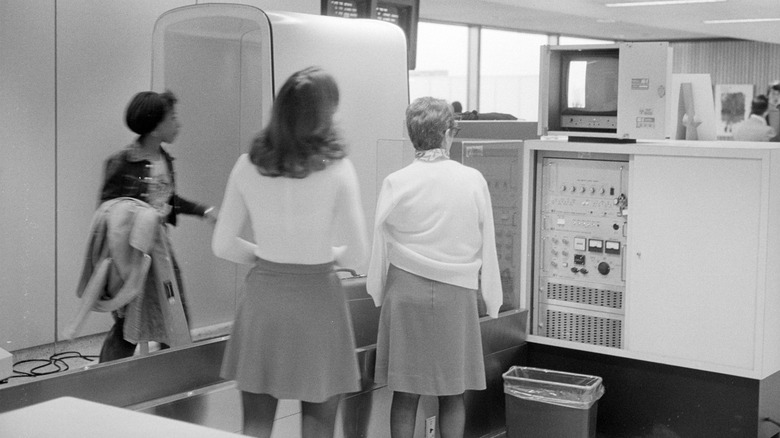 Airport security personnel stand in front of a magnetometer passenger scanner on March 6, 1974, at the National Airport, Washington DC.