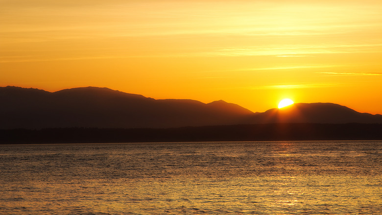 A sunset over water and mountains