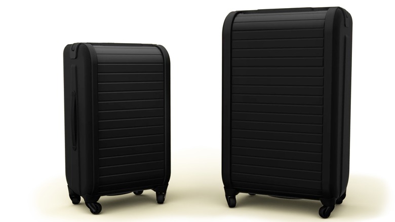 Two black Trunkster suitcases standing upright with a white background