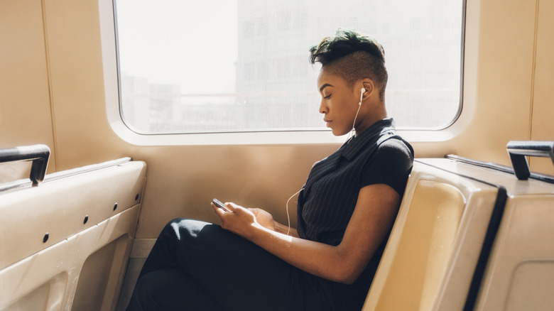 Young businesswoman using her cellphone on a train.