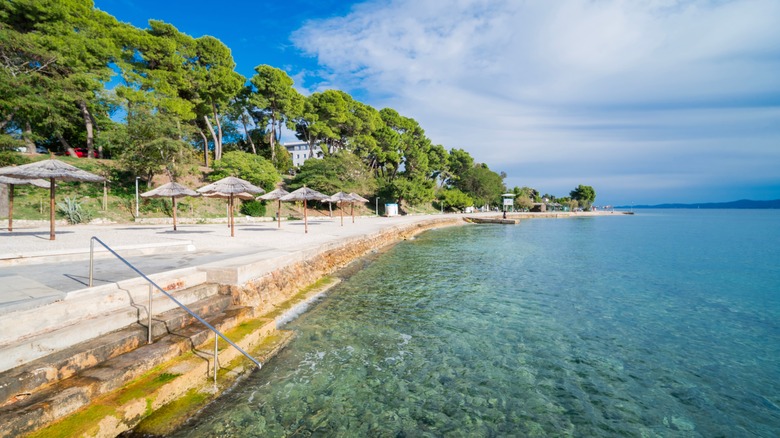 steps leading into clear blue water along a beach
