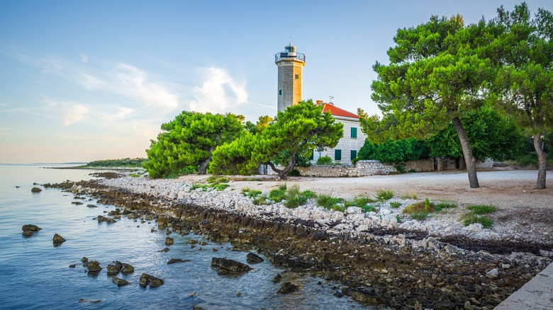 view of the beach with lighthouse in background