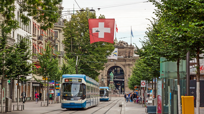 Tram heading down Zurich's famous shopping street, the Bahnhofstrasse, under a Swiss flag