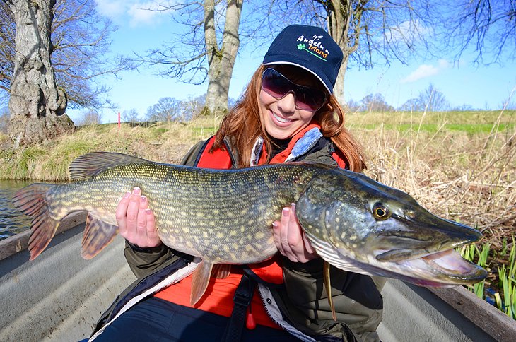 Anietra holding a pike in the Great Western Lakes