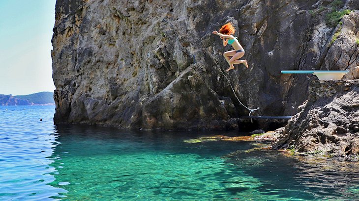 Leaping off the diving board at La Grotta Beach