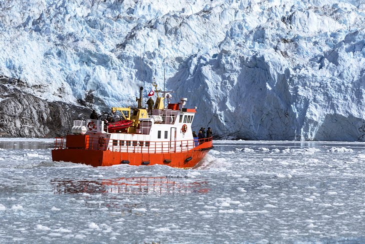 A tourist boat taking pictures of an iceberg