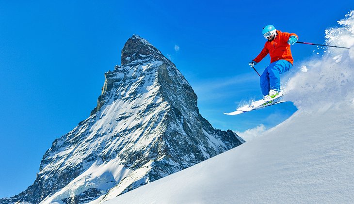 A skier in fresh powder next to the Matterhorn
