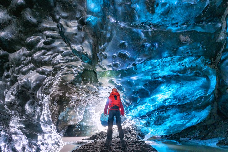 Hiker in an ice cave in Vatnajokull, Iceland