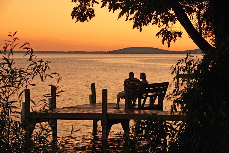 Un couple profitant du coucher de soleil sur le lac vert