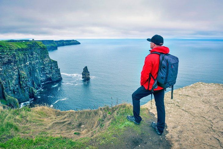Hiker enjoying the view of the Cliffs of Moher