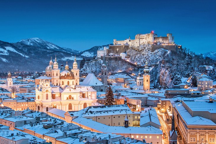 Salzburg Cathedral and the famous Festung Hohensalzburg at dusk in wintertime