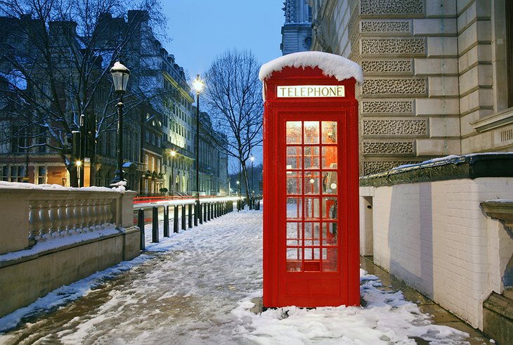 Red telephone booth in London on a wintry evening