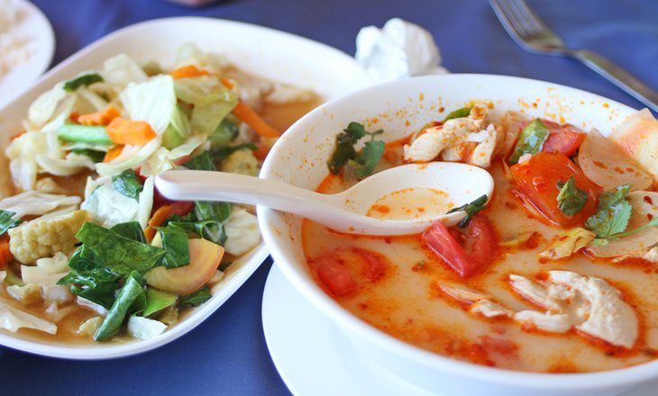 Une soupe de poulet à la noix de coco et des légumes complètent un repas en Thaïlande.