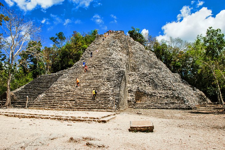 Visiteurs escaladant la pyramide de Cobá