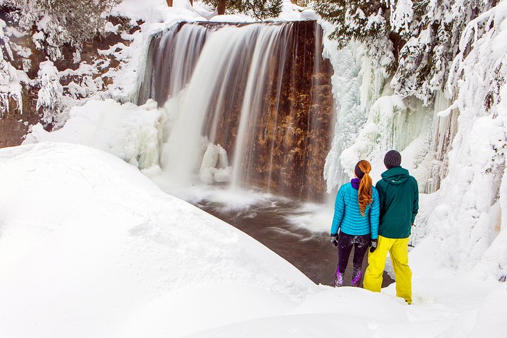 Couple enjoying a waterfall near Whistler in the winter
