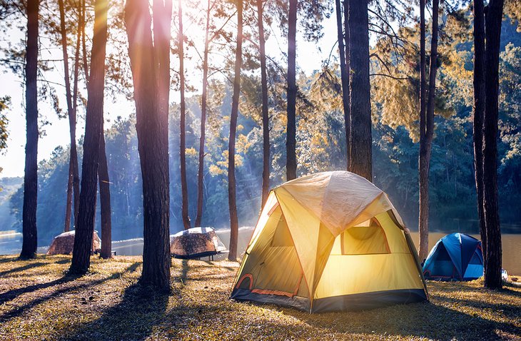 Tents in the morning light along a river