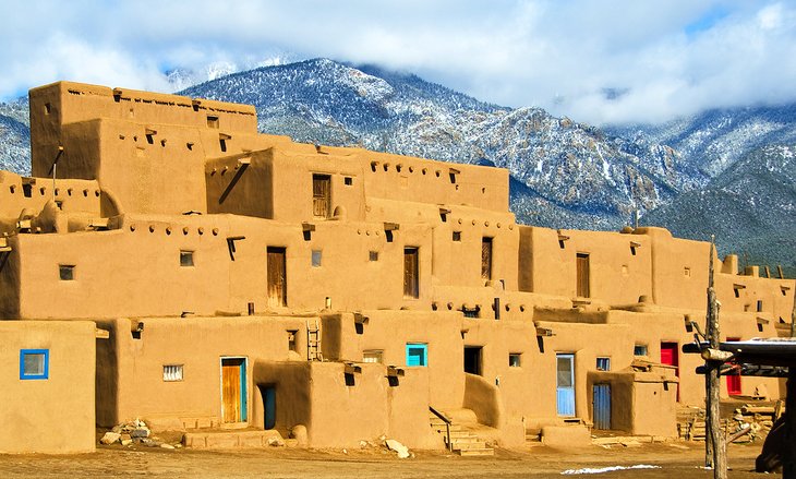 Taos Pueblo with snowcapped mountains