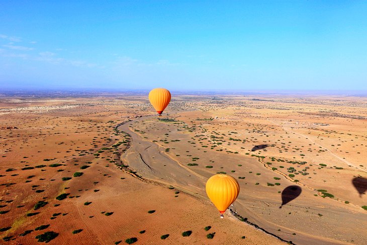 Hot-air balloons fly over the arid plateau surrounding Marrakesh