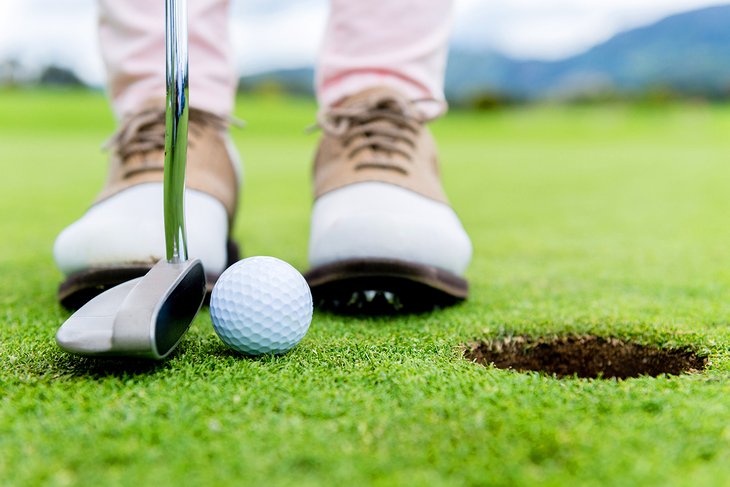 Golfer putting near the hole